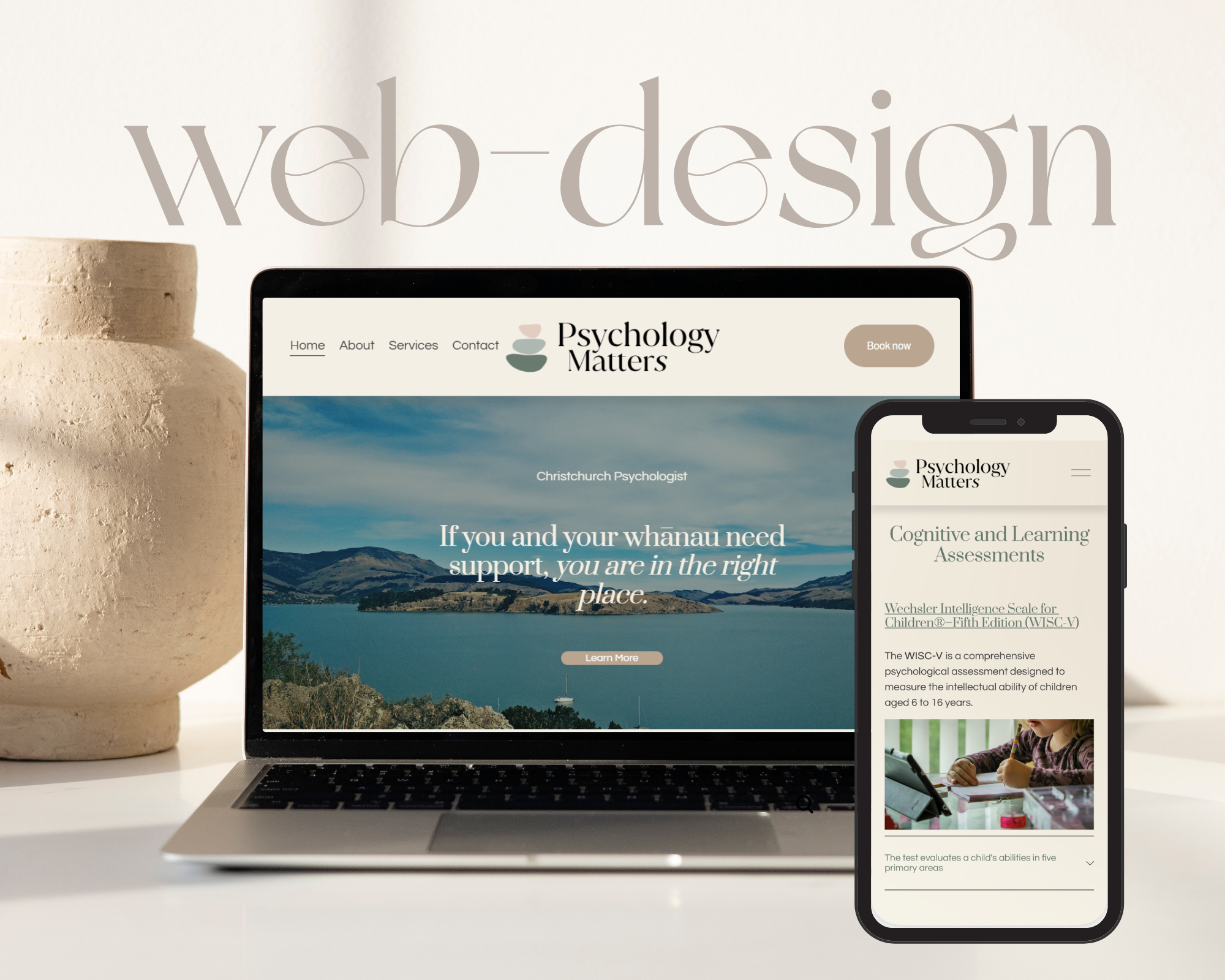 Laptop and smartphone displaying a mental health website called Psychology Matters, with scenic lake and mountains background, and a beige pottery vase to the left.