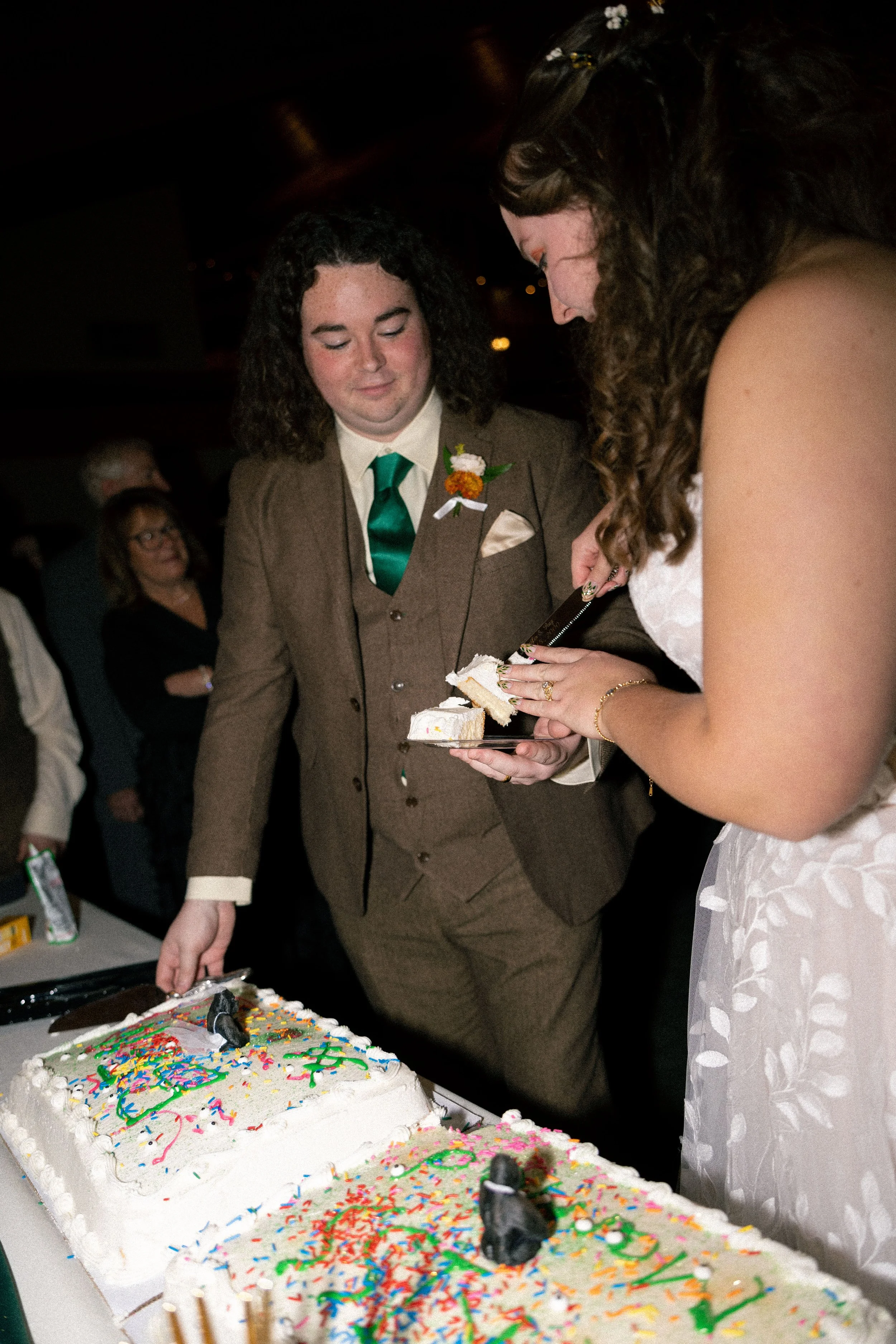 A bride and groom cutting a wedding cake together at their wedding reception.