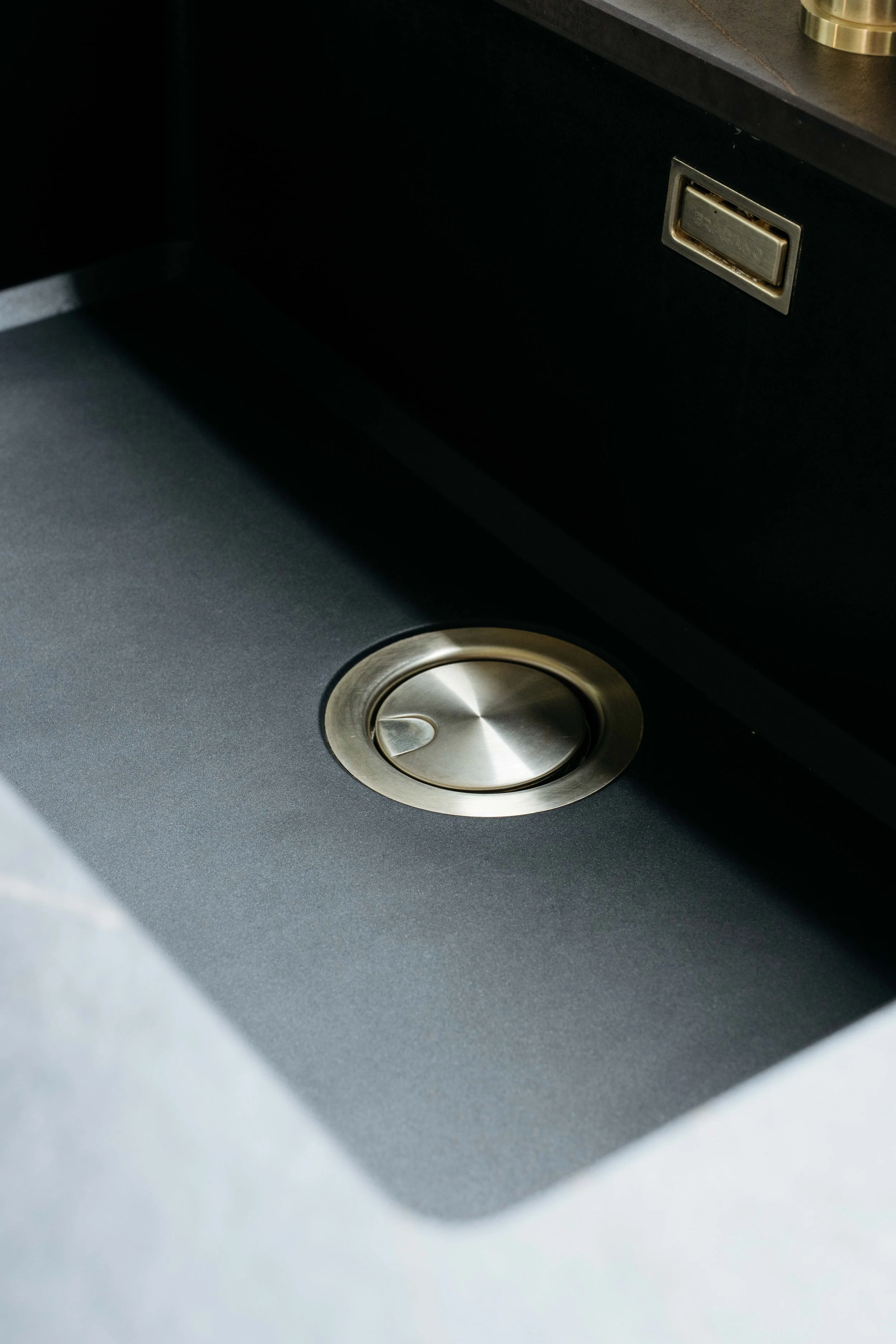 En köksdiskho med en avlägsen avloppspropp och ett eluttag i bakgrunden.