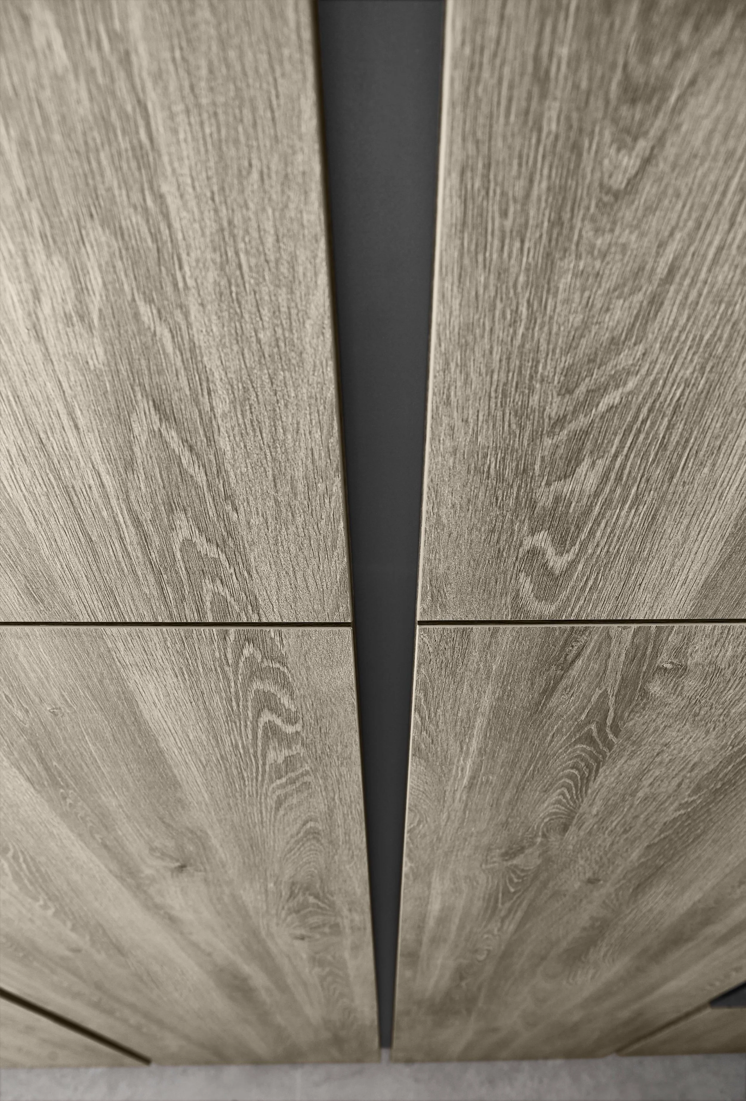 Närbild av ett tak med träfaner och en mörk, avlång ventilationsskiva.