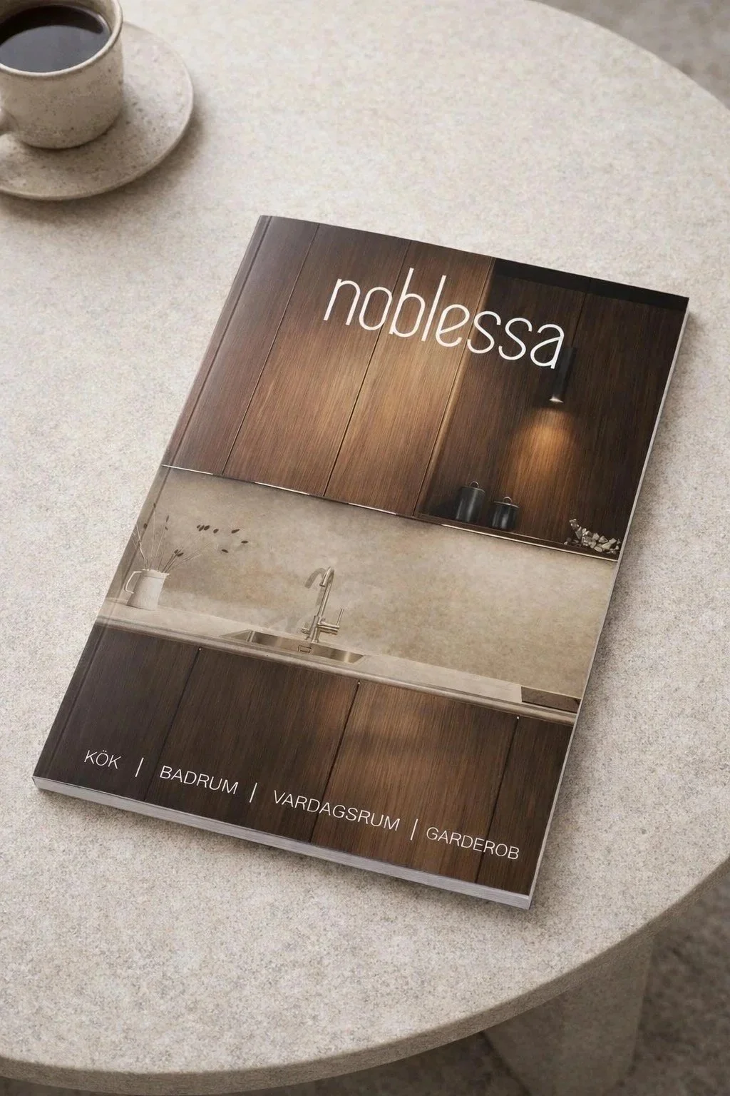 En broschyr med titeln "noblessa" som visar ett kök med trädörrar, en diskho och arbetsbänk. Text längst ner på broschyren nämner kök, badrum, vardagsrum och garderob.