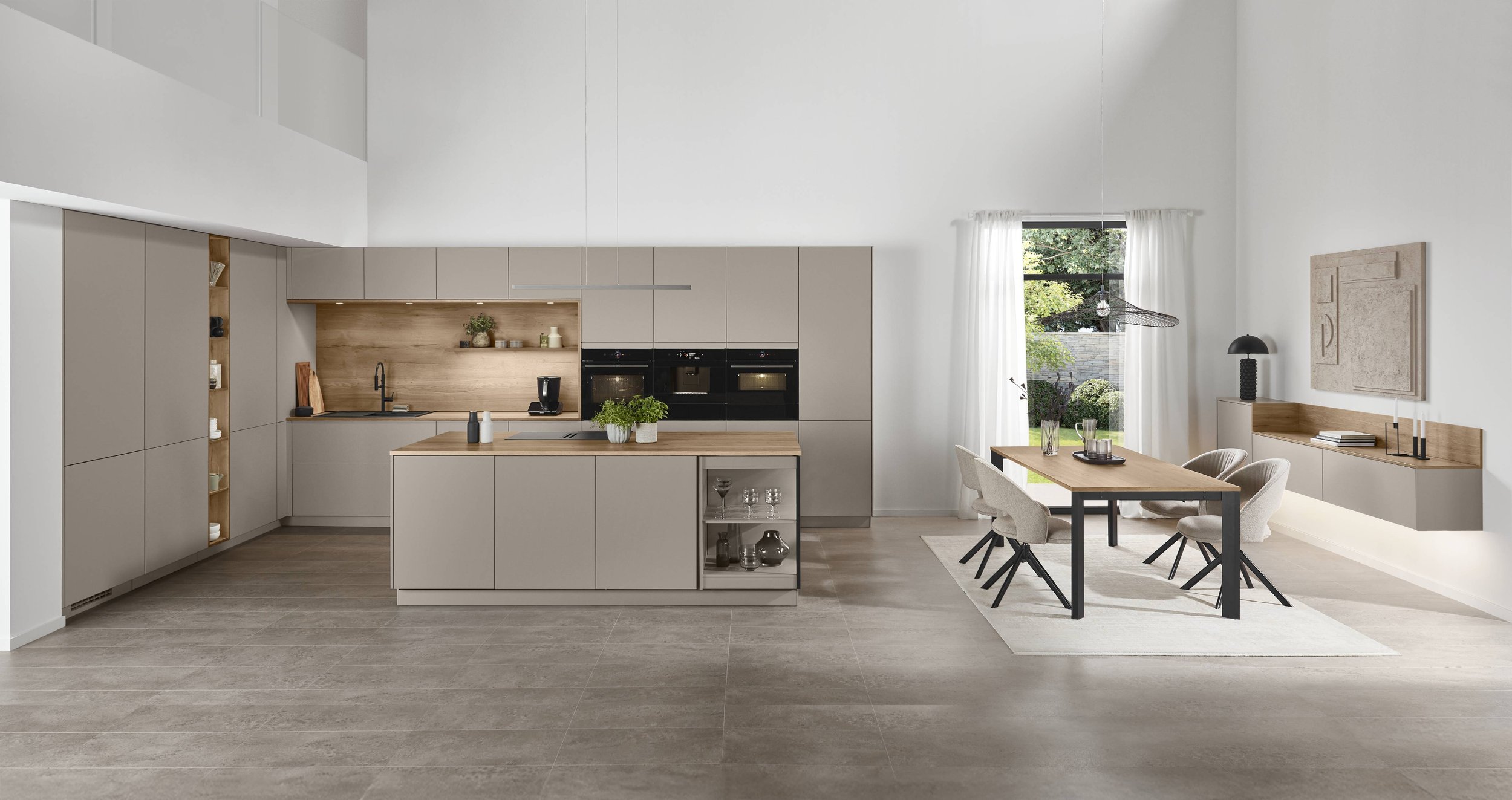 Moderna kök med inbyggda ugnar, ett vitt köksö med skåp, träluckor, ett dekorativt blompannk i keramik och luftiga, ljusa kläddes av golv och väggar.