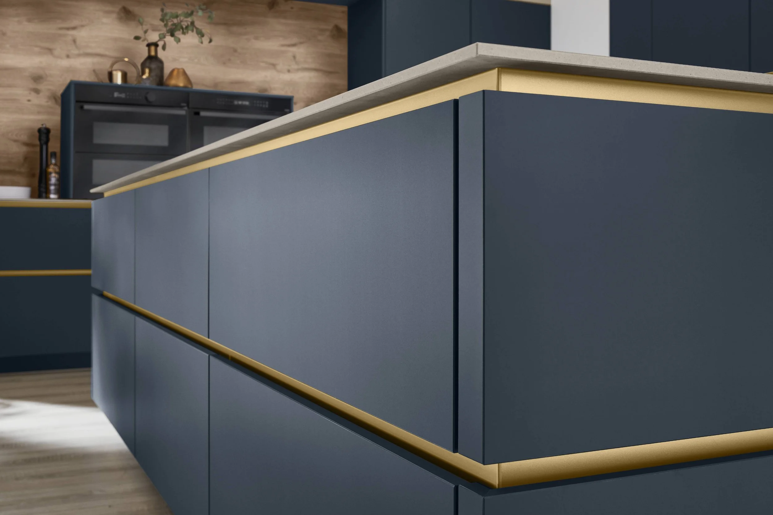 Nära bild av ett kök med blå skåp och ett marmorerat köksbänk.