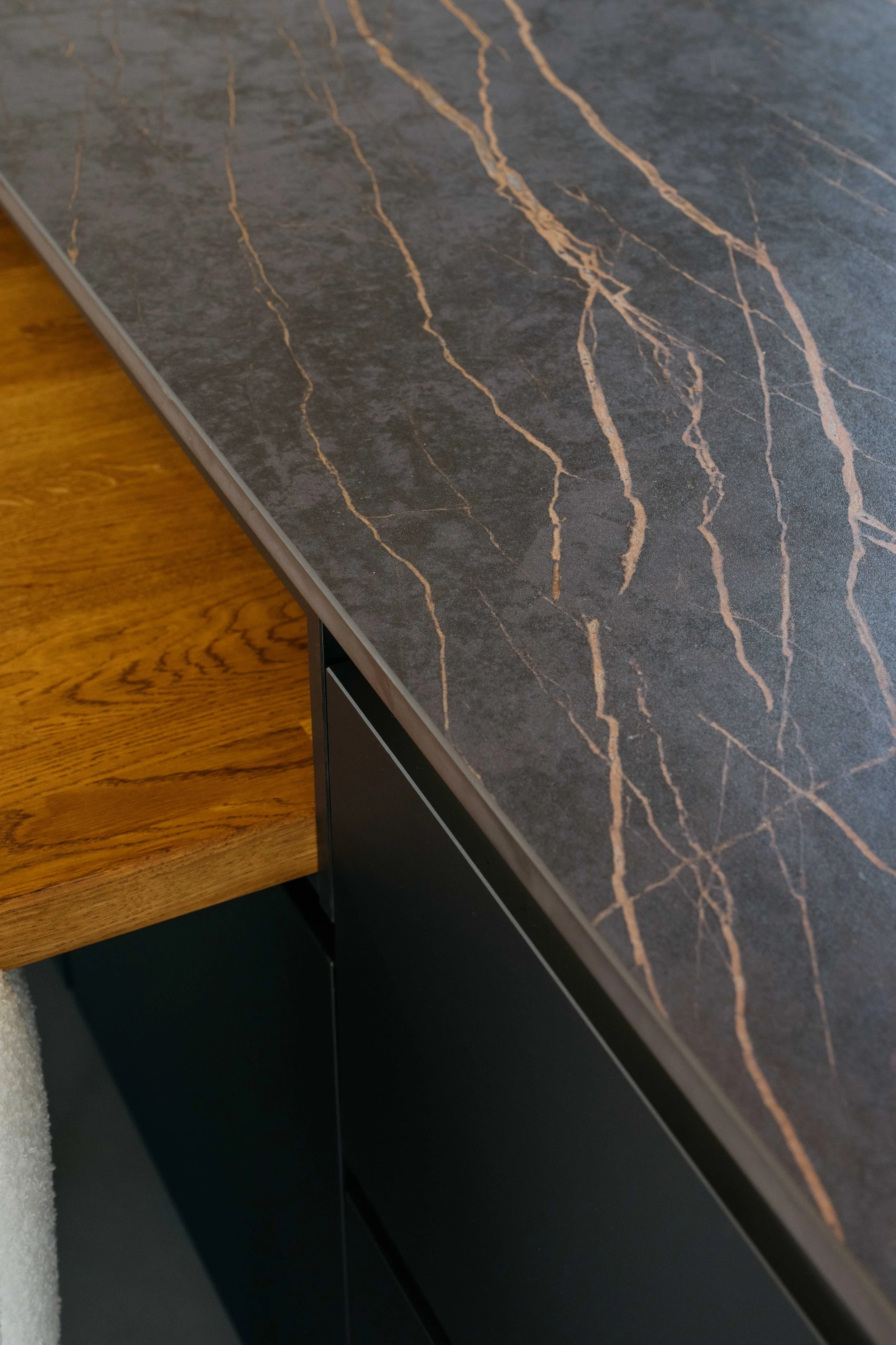 Kantskikt av mörk sten med olika ljusare ådringar ovanpå en möbel, del av ett hem eller kontor