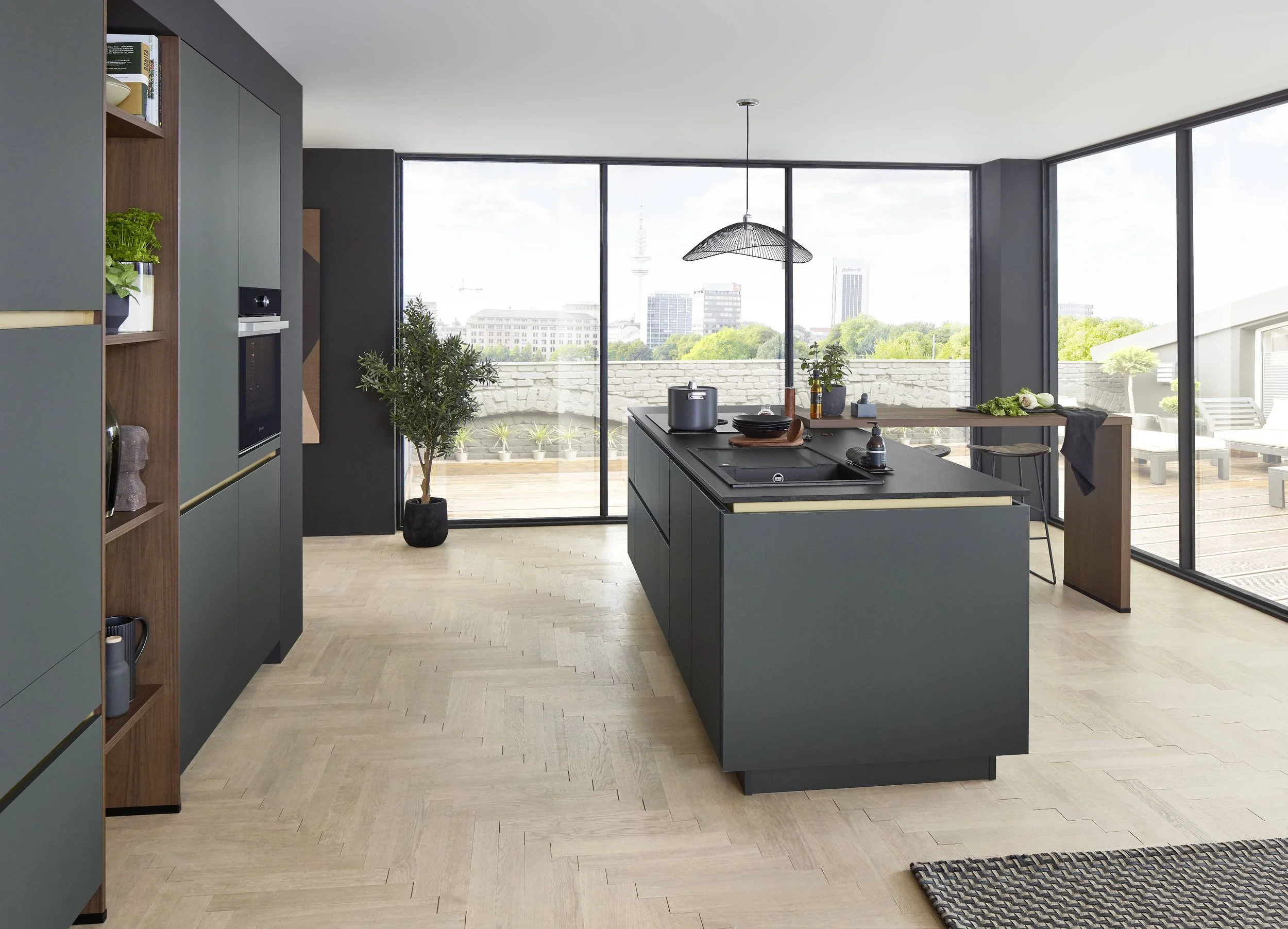 Modern köksinredning med ett köksbord och utsikt mot staden genom stora glasfönster.