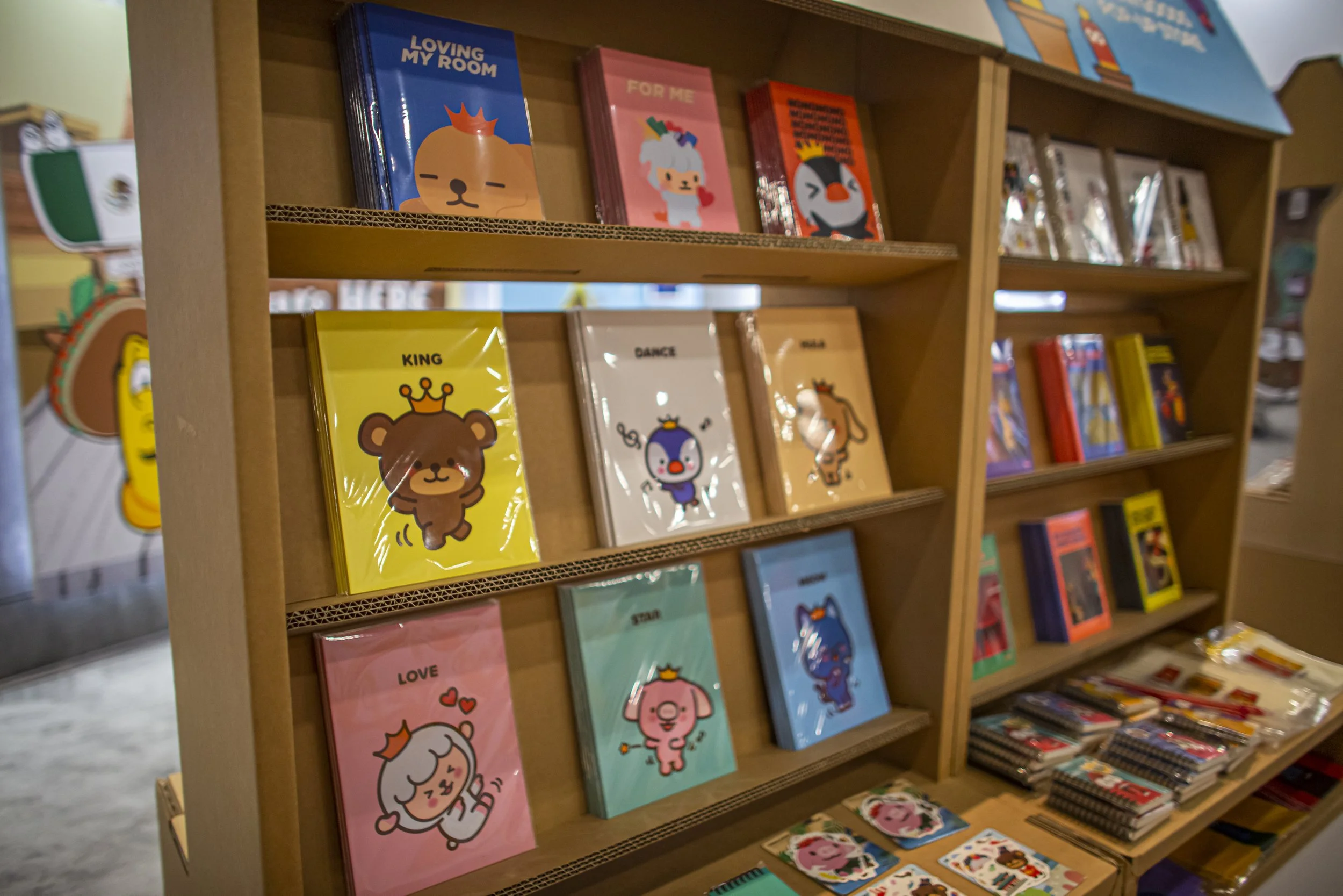 Colorful cartoon character books on wooden shelves in a store.