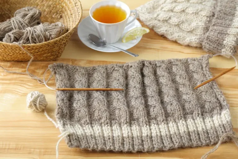 knitted-beanie-sweaters-wooden-table-cup-tea-basket-yarn-200781309.webp