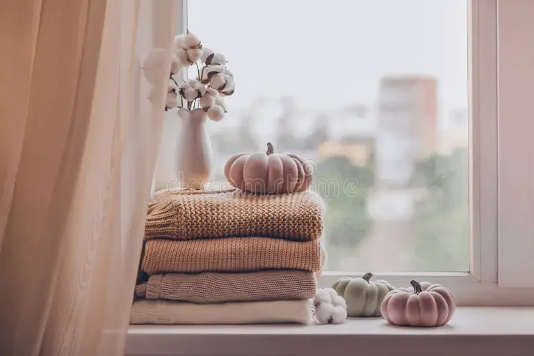 stack-warm-knitted-sweaters-windowsill-pumpkins-vase-cotton-plant-pastel-shades-rainy-day-232667365.webp
