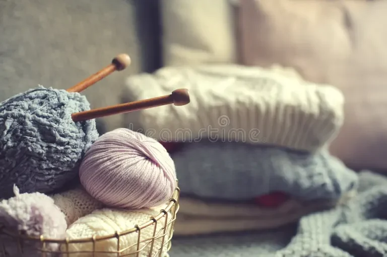 grey-pink-yarn-ball-knitting-needles-metallic-basket-knitted-sweaters-background-hobby-cozy-homely-weekend-hygge-107461018.webp