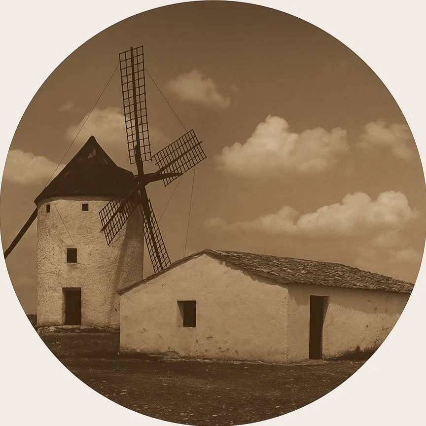 Molino de viento tradicional con estructura de piedra y techo de tejas, bajo un cielo con nubes en tonos sepia.