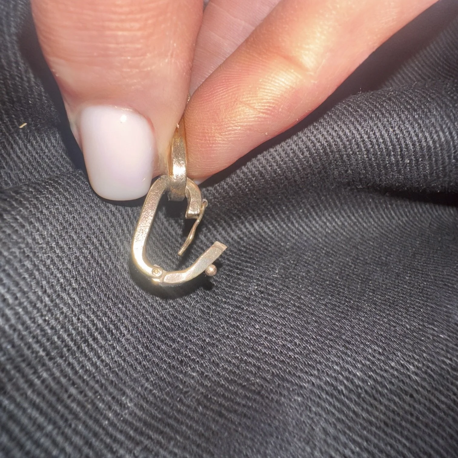 Close-up of integrated clasp and safety catch on vintage 9K yellow gold curb link bracelet