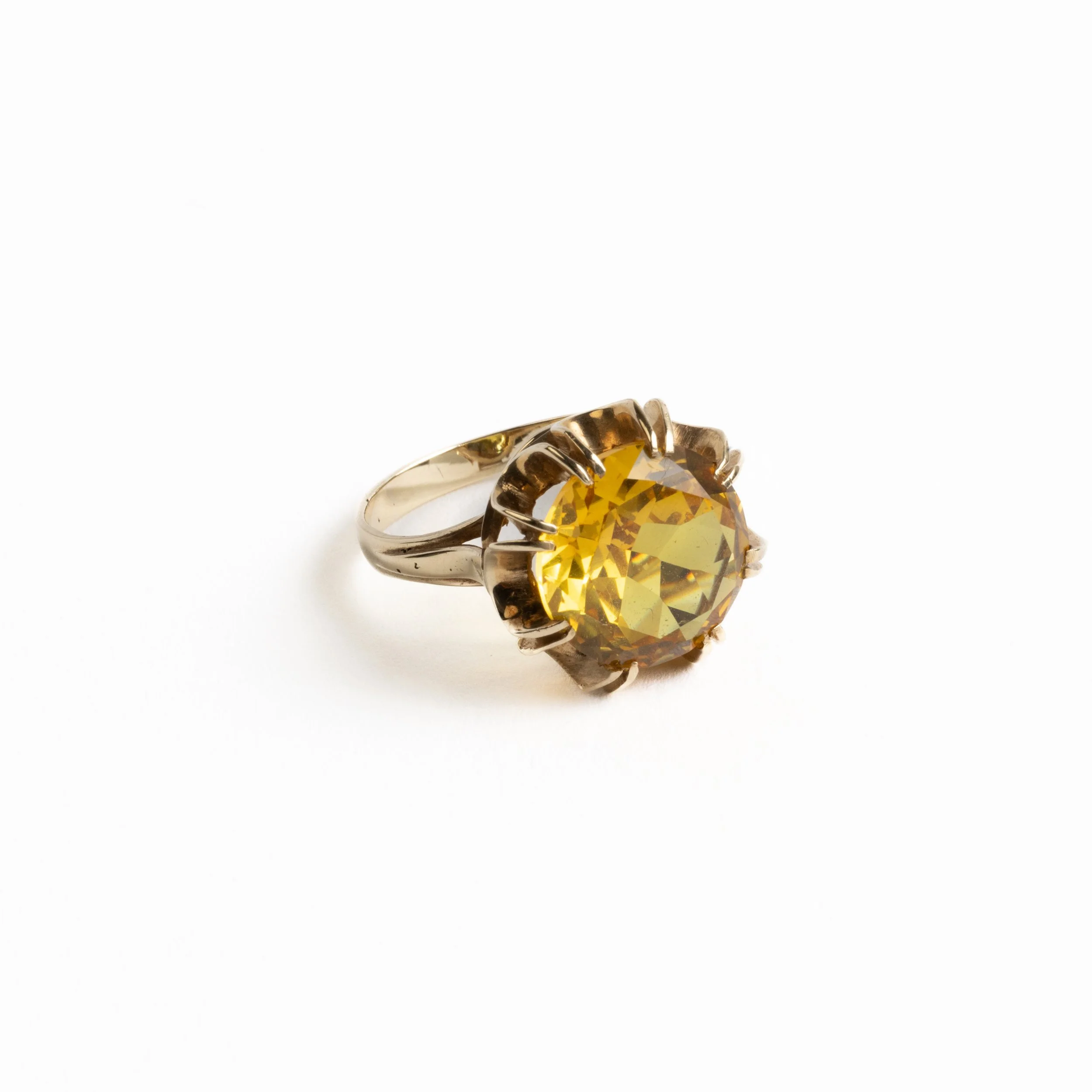 Vintage 14ct yellow gold ring set with a large citrine-hued faceted gemstone in a sculptural flared claw setting, photographed on a light background.