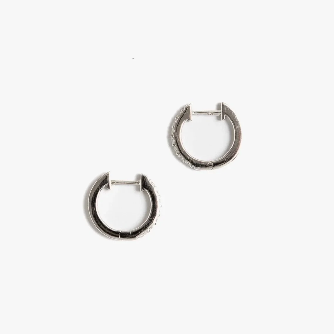 Carrie Diamond Huggie Earrings in 9ct yellow gold, set with 14 white brilliant-cut diamonds, photographed on soft linen in natural light