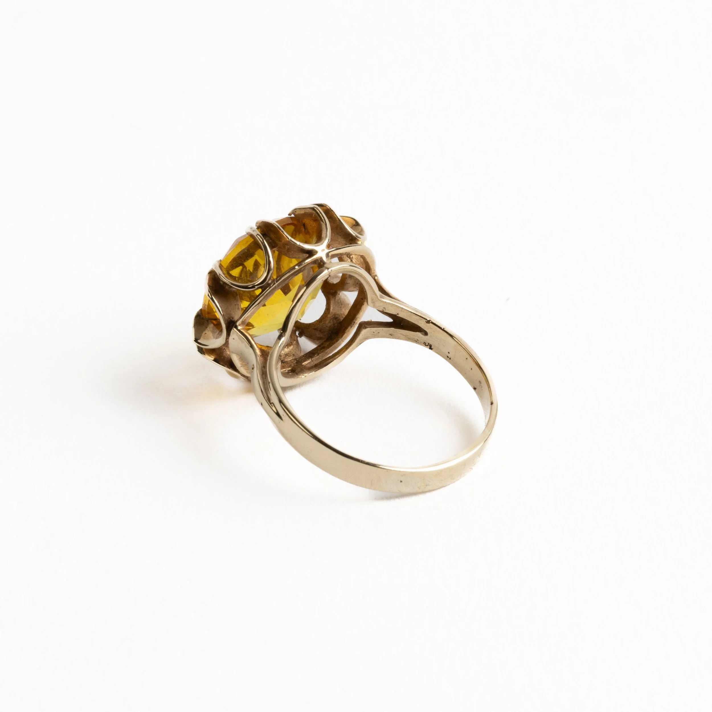 Vintage 14ct yellow gold ring set with a large citrine-hued faceted gemstone in a sculptural flared claw setting, photographed on a light background.