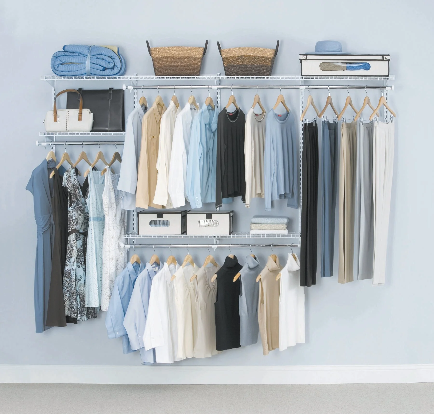 Organized closet wall with hanging shirts, pants, and accessories, featuring wire shelves and storage bins.