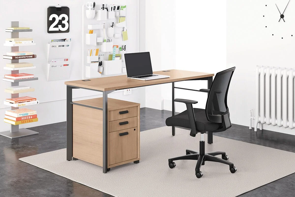 Modern home office with a wooden desk, black office chair, white wall decorated with a large clock and a hanging calendar, and a white bookshelf with books and organization containers. There's a white radiator on the wall and a light-colored rug on a dark floor.
