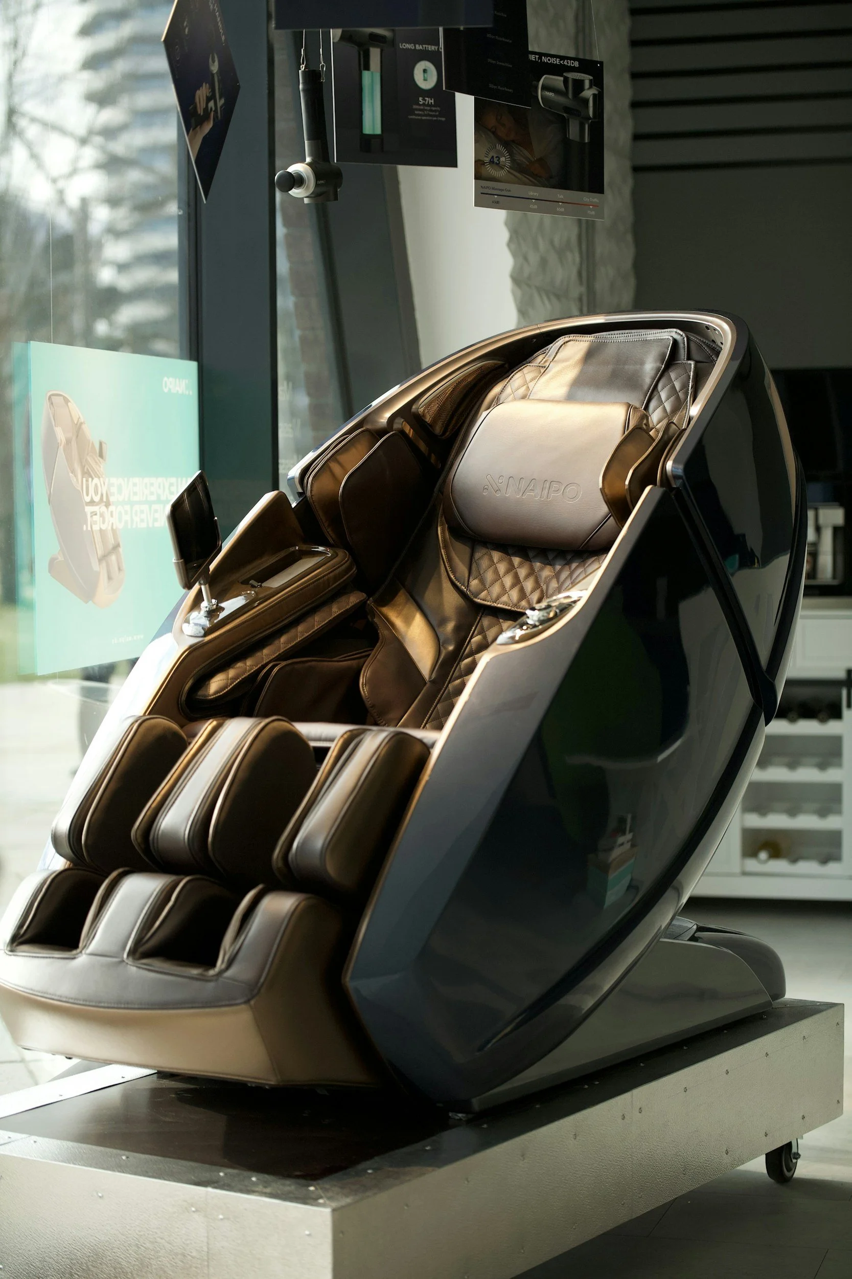 A luxury massage chair with leather upholstery and multiple padded sections, situated in a modern interior near a glass window.