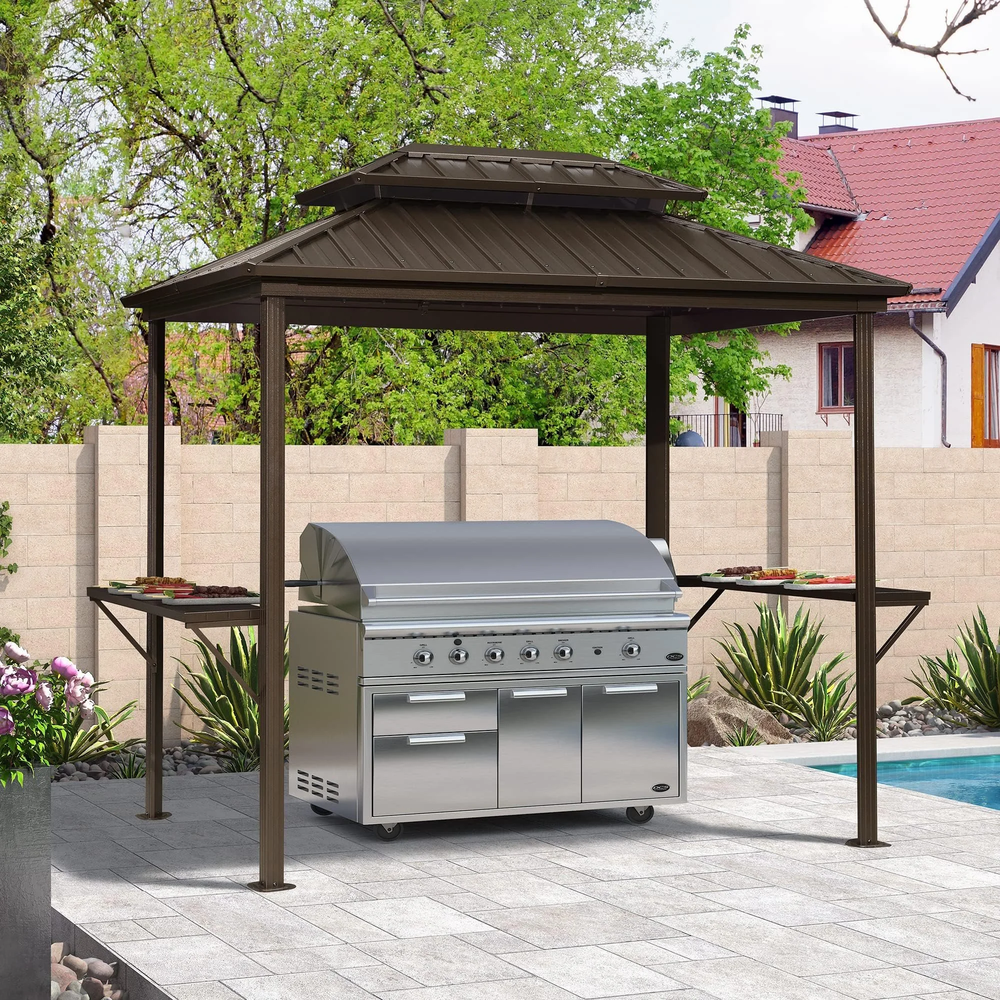 A backyard patio features a stainless steel gas grill under a brown metal gazebo with a hexagonal roof, surrounded by plants and a swimming pool.