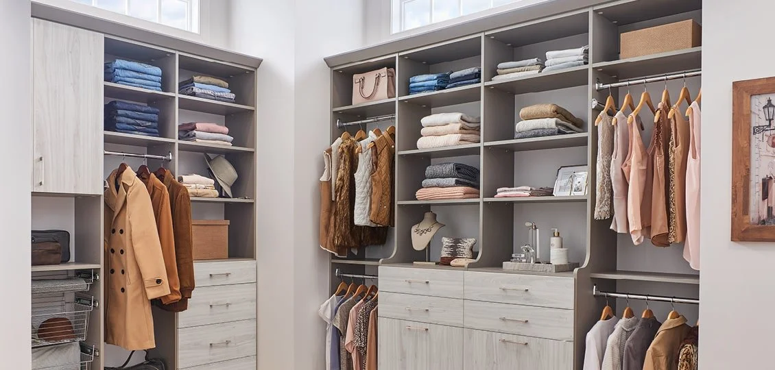 Organized walk-in closet with shelves, hanging clothes, and accessories.