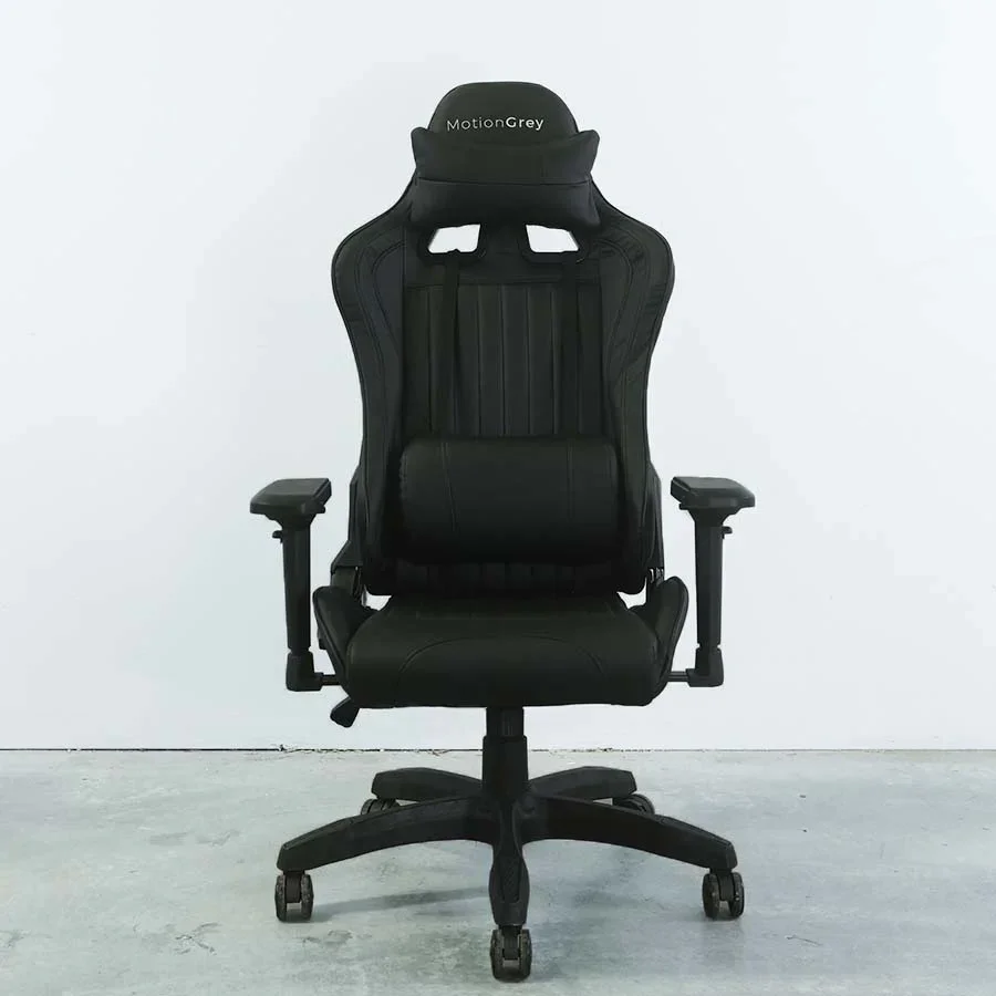 Black ergonomic office chair with adjustable armrests and a high backrest, placed against a plain white wall.
