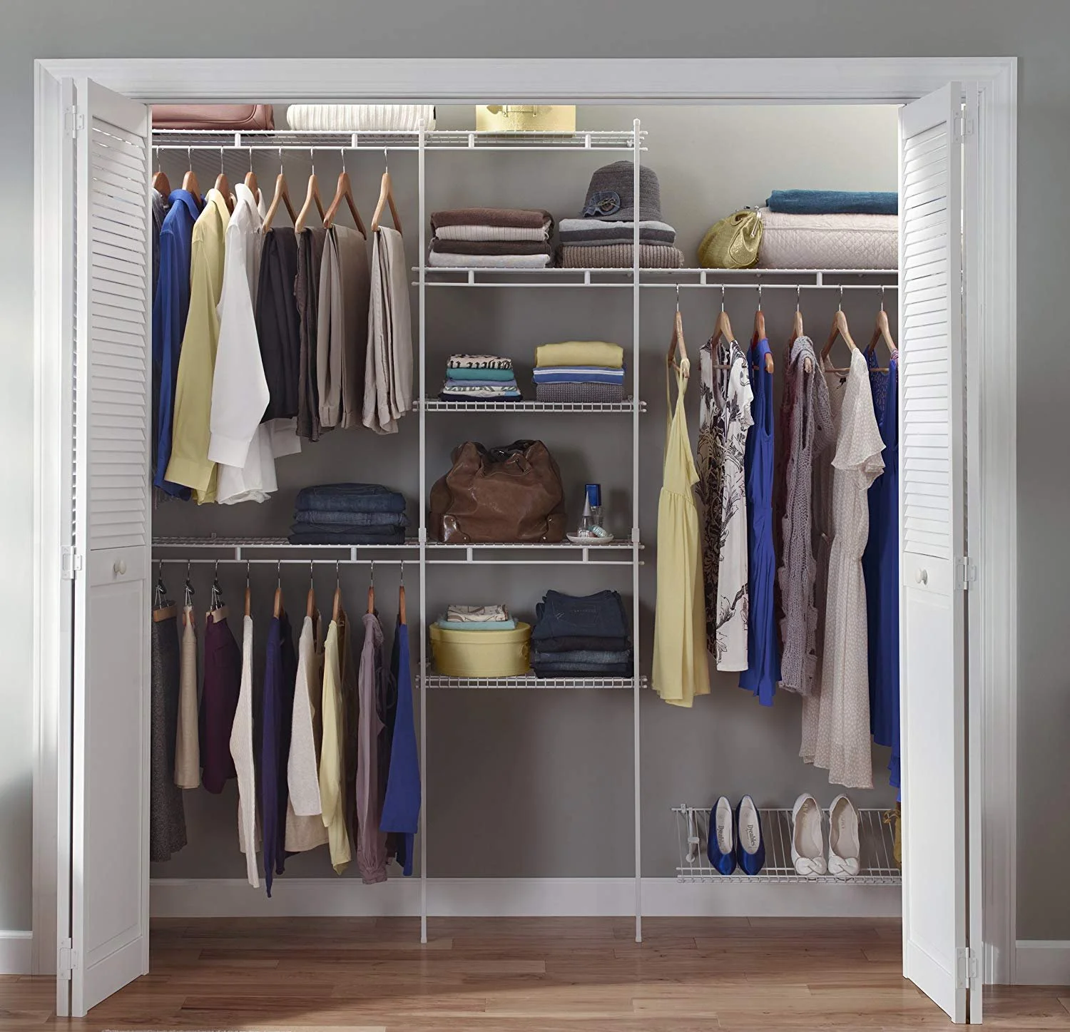 Open closet with clothes, shoes, and accessories on white wire shelves and hanging rods.