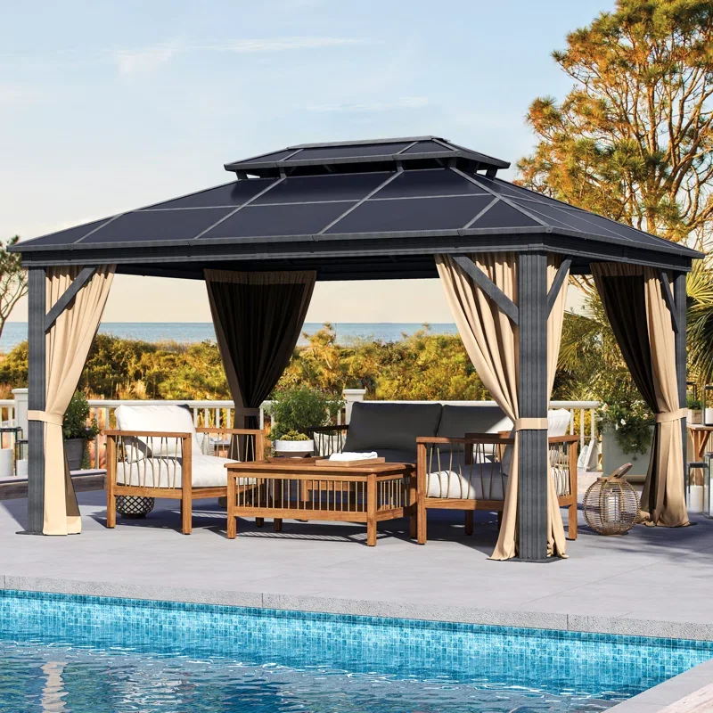 Outdoor seating area with a gazebo near a swimming pool, surrounded by trees and a fence, overlooking a natural landscape and the ocean in the distance.