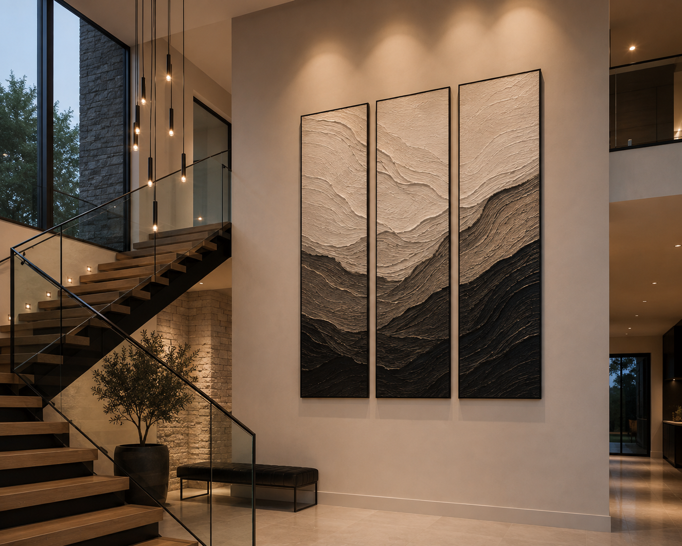 Large triptych artwork installed on a double-height feature wall beside a modern staircase in a luxury home.