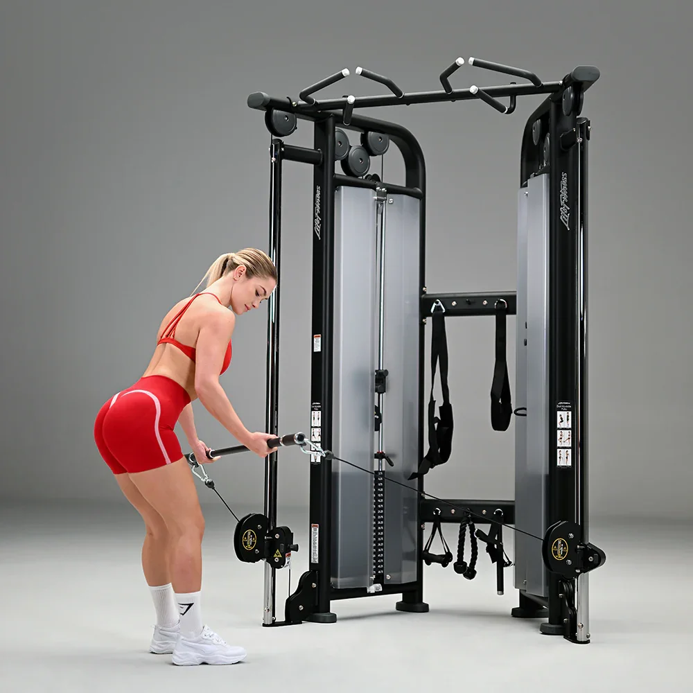 A woman in red workout attire using a cable machine in a gym.