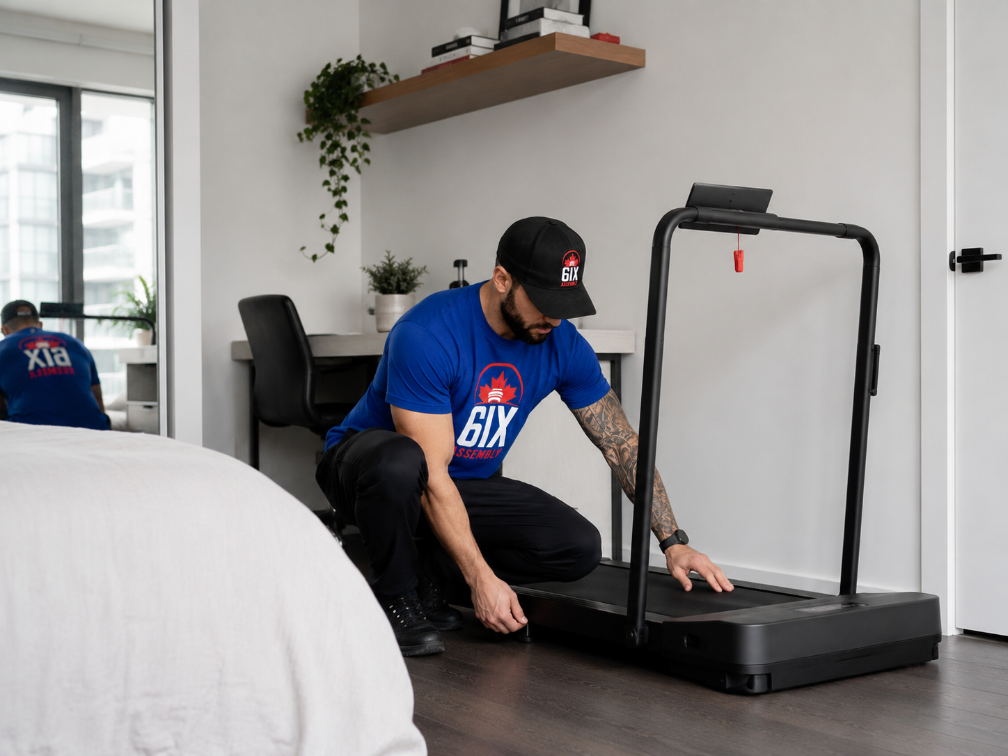 6IX Assembly technician setting up a compact treadmill in a small bedroom or home office.