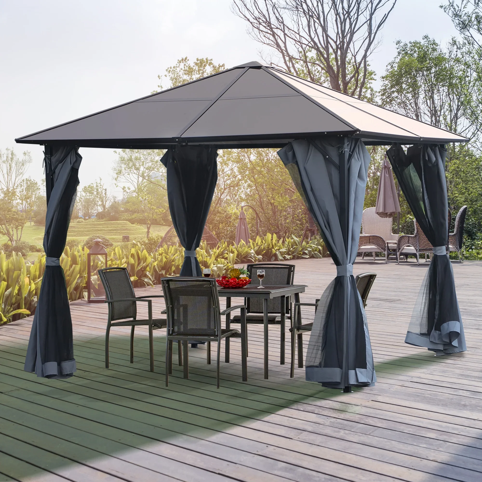 Outdoor patio with a black gazebo, black curtains, and a wooden table with four chairs, set on a wooden deck with garden greenery in the background.