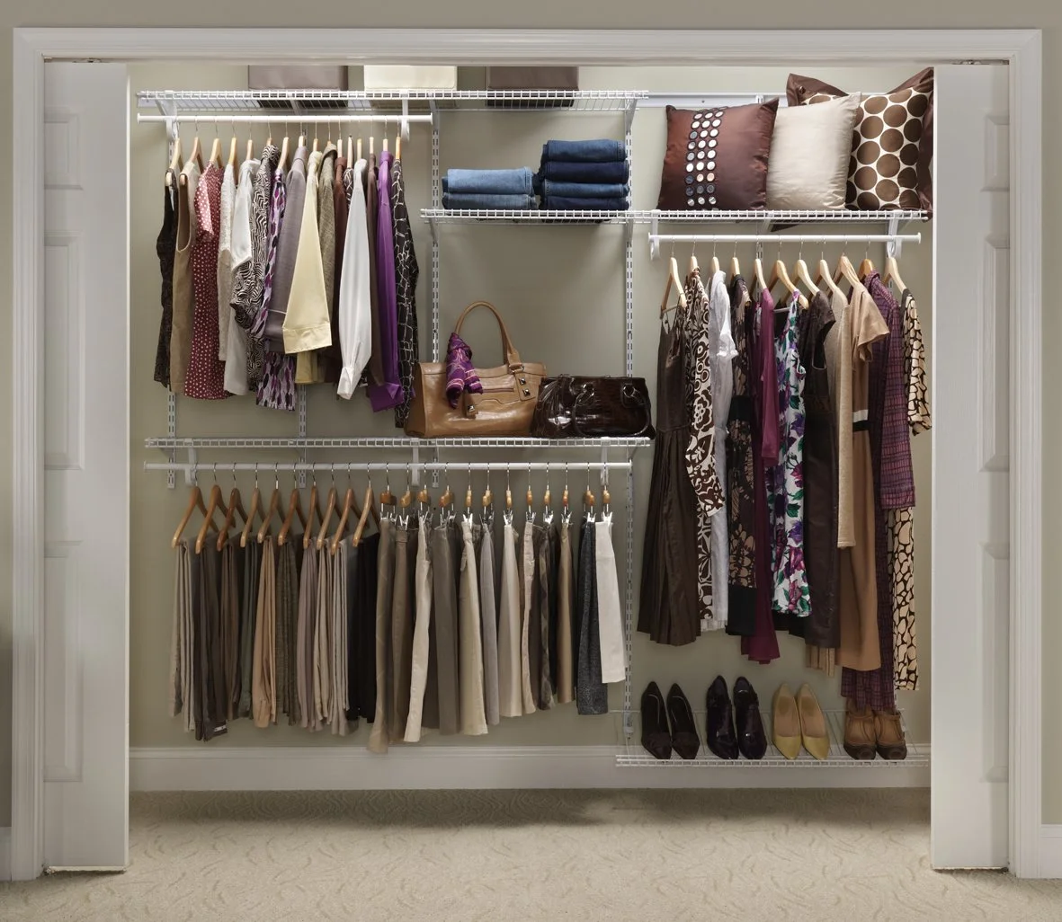 Closet with organized clothing, handbags, shoes, and decorative pillows.