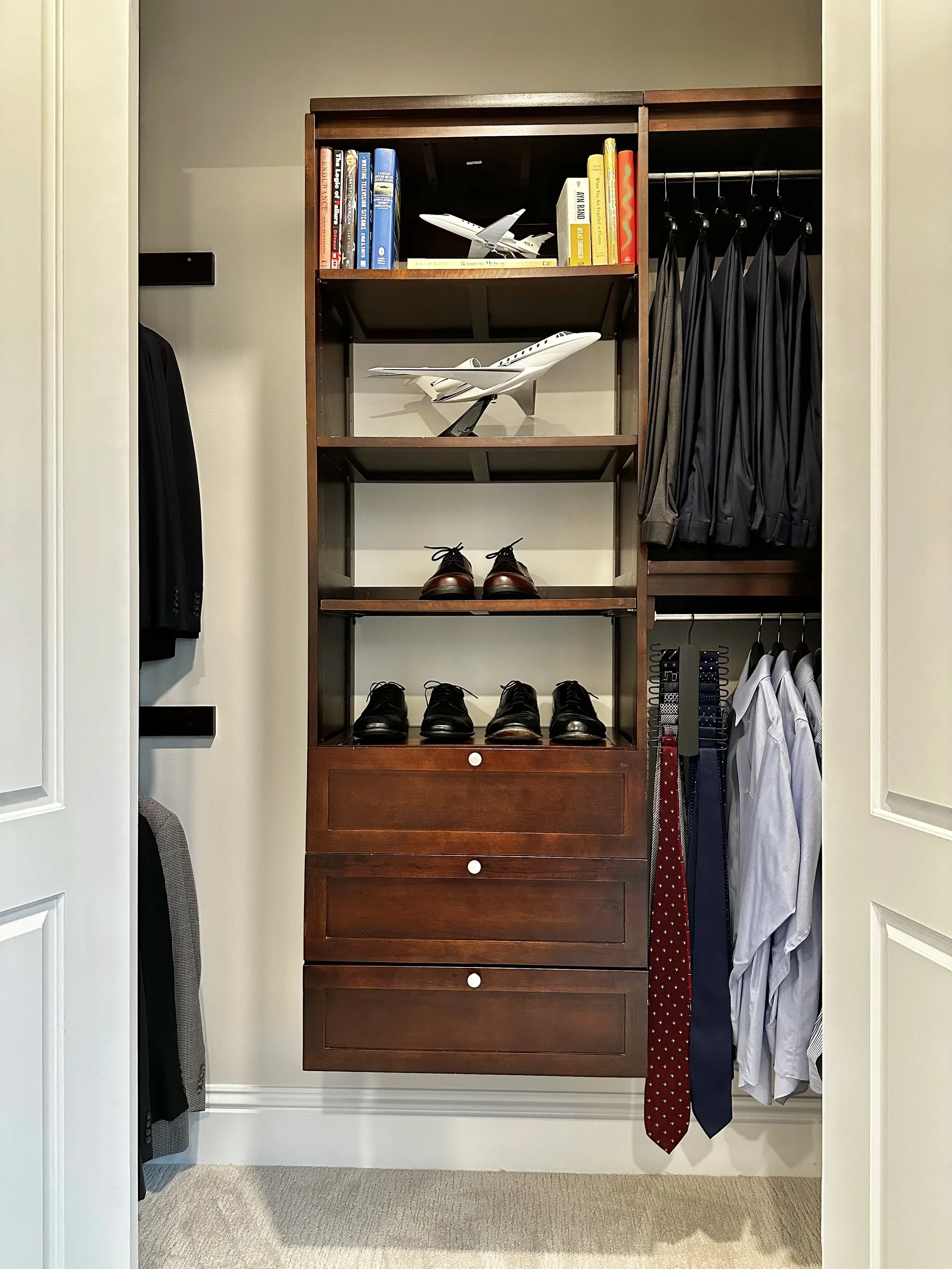 Closet with shelves holding model airplanes, books, shoes, and dresses
