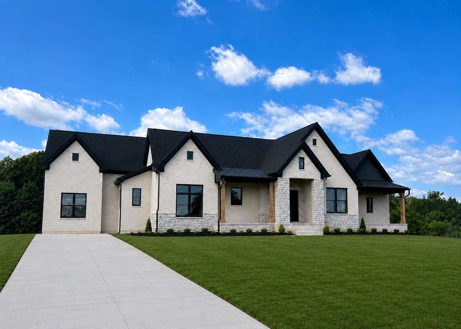 A modern two-story house with white brick walls, black roof, and a concrete driveway leading to the front entrance, surrounded by a green lawn and trees under a blue sky with scattered clouds.