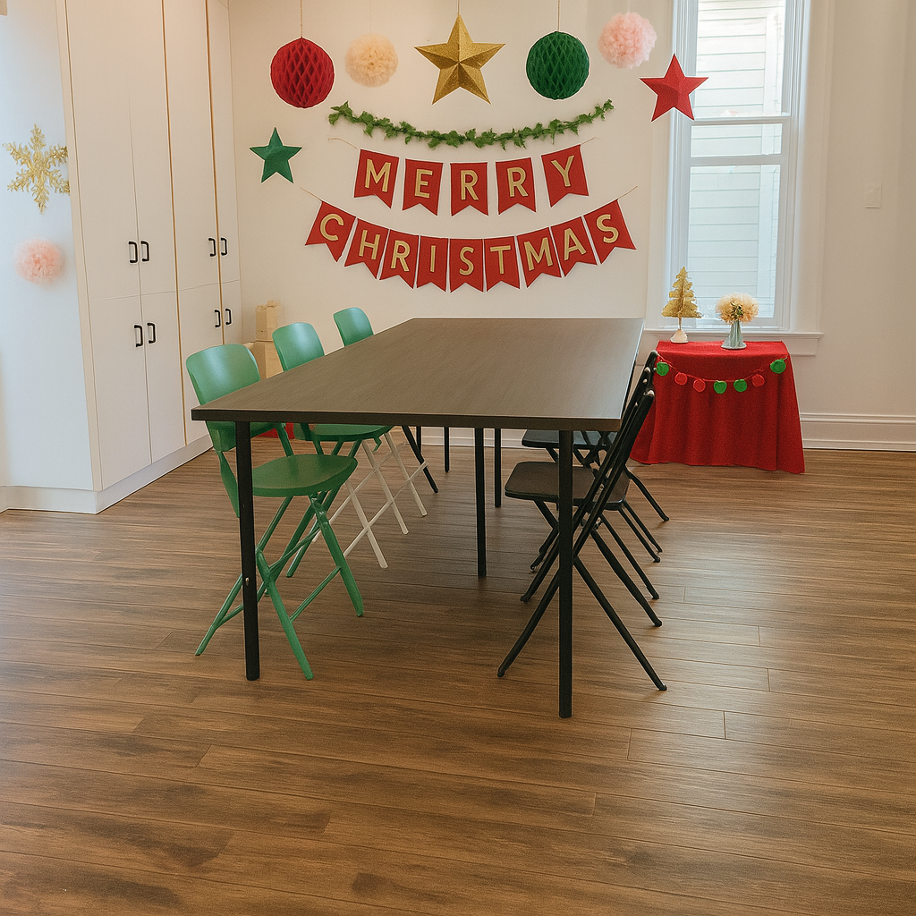 A decorated room for Christmas with a table and chairs, Christmas banners, ornaments, and a small table with holiday decorations near a window.
