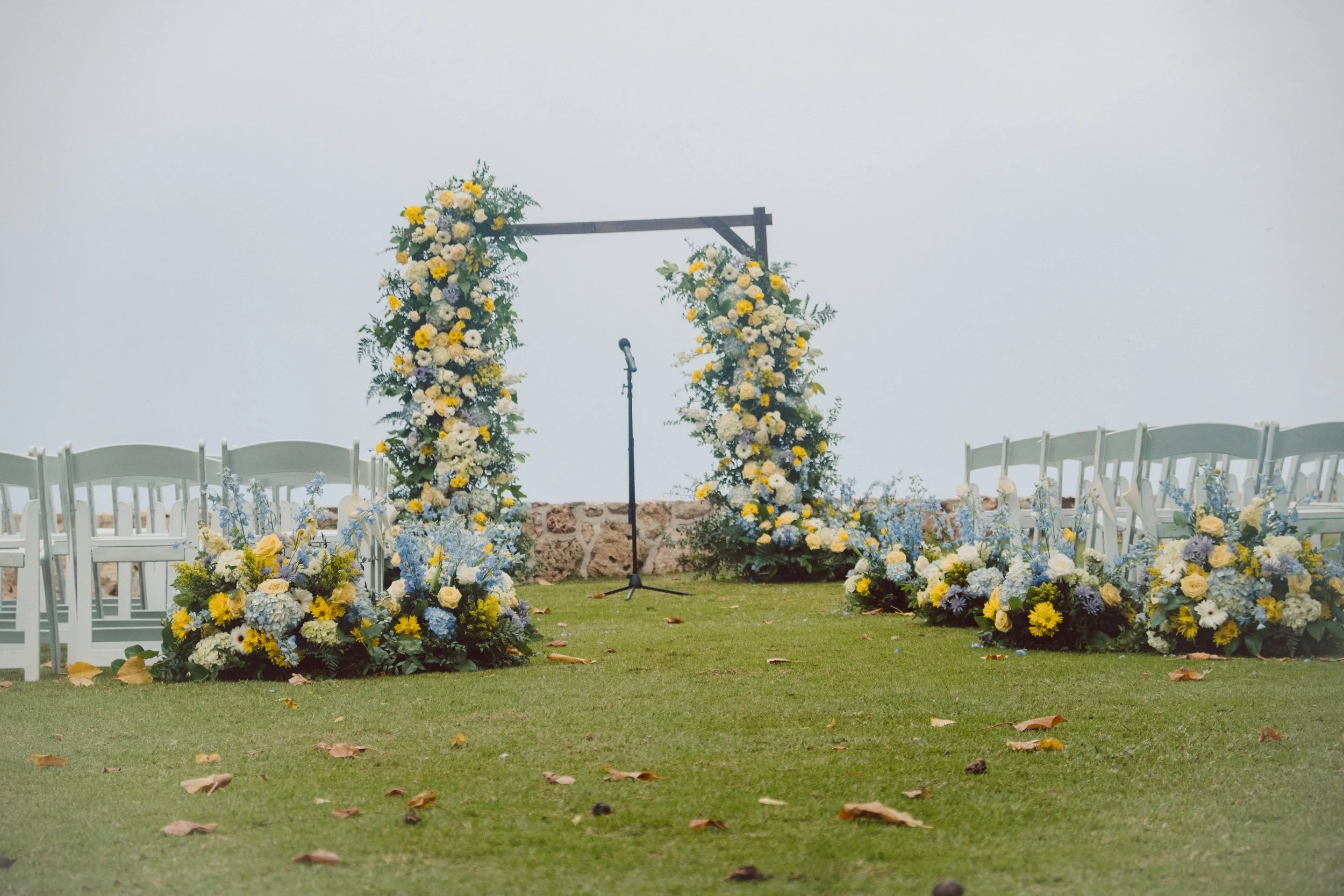 Fresh flower wedding ceremony arch at Lanikuhonua in Ko Olina, Oahu with oceanfront backdrop