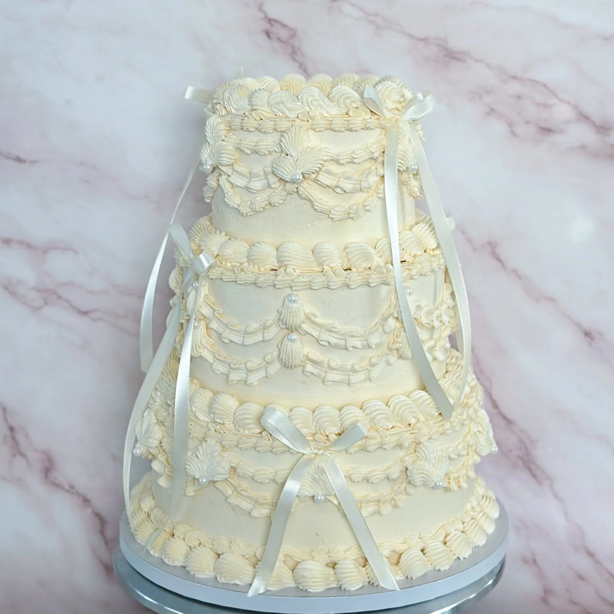 Pink birthday cake with a pink crown topper, decorated with pink and white roses, green leaves, and golden butterflies. The cake has the number 3 and the name 'elsa' written on it.