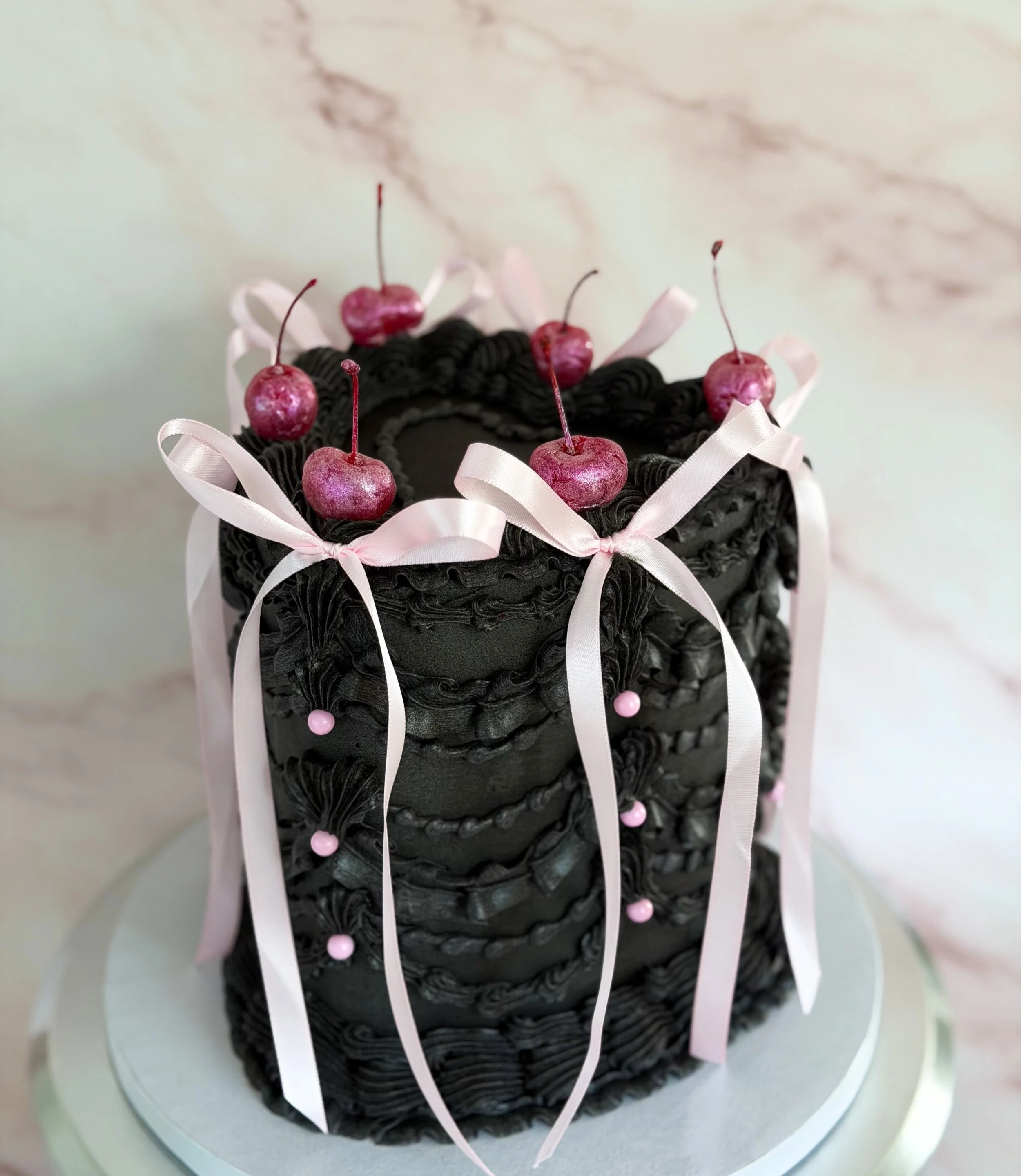 Pink ribbons against black buttercream is a combo I didn&rsquo;t know I needed🥹🎀

And in other exciting news&hellip; pickup ordering is officially available now!!🥳
The new order form also has a calendar feature built in for both pickup and deliver