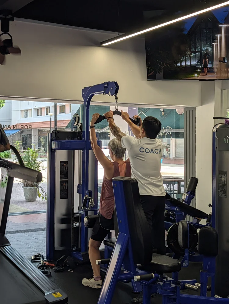 Older woman performing a coached strength exercise
