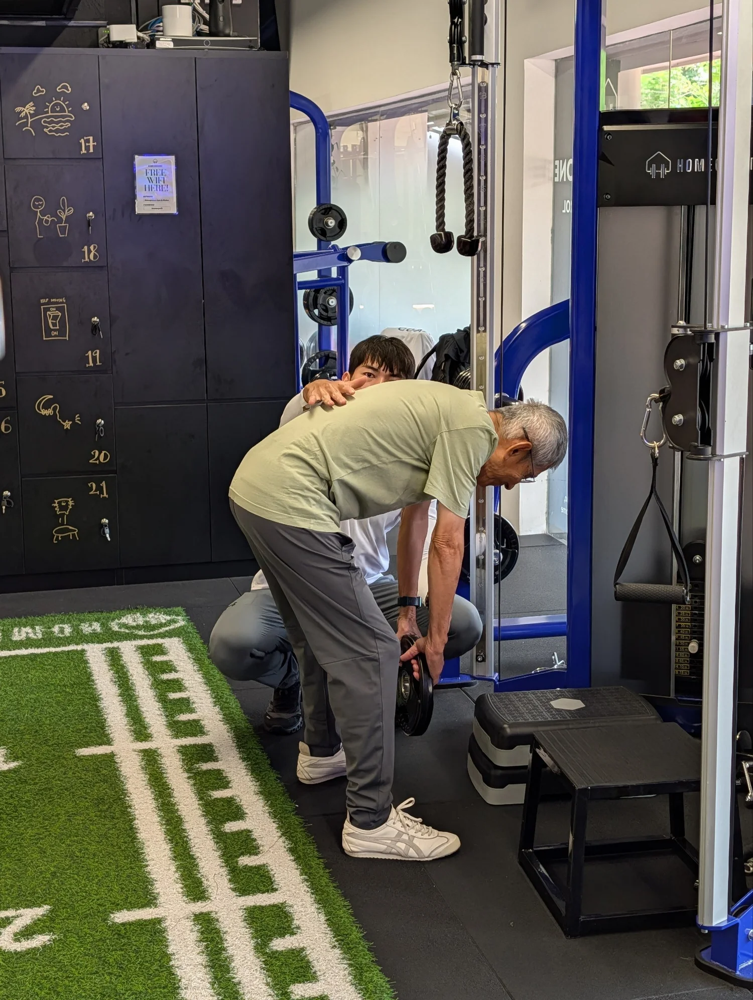 Older man completing resistance training with a personal trainer