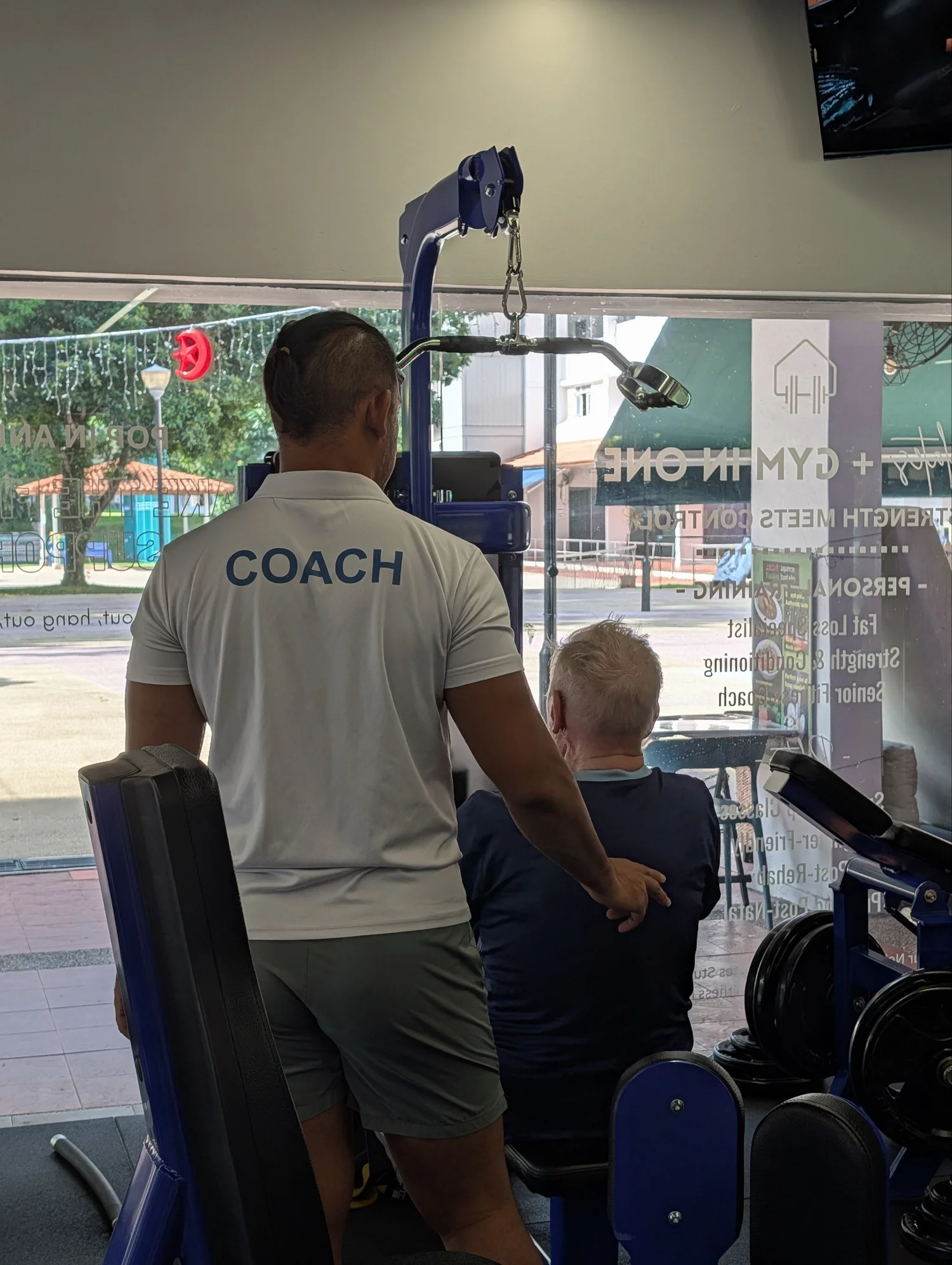 Personal trainer guiding an older adult through a safe workout