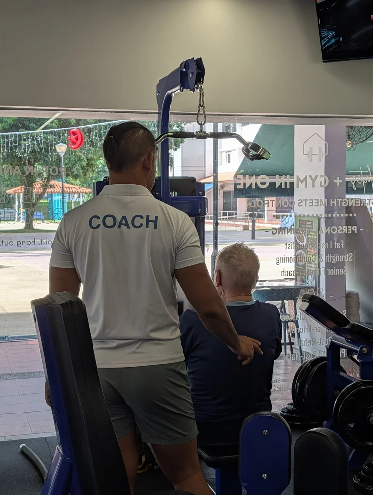 Personal trainer guiding an older adult through a safe workout
