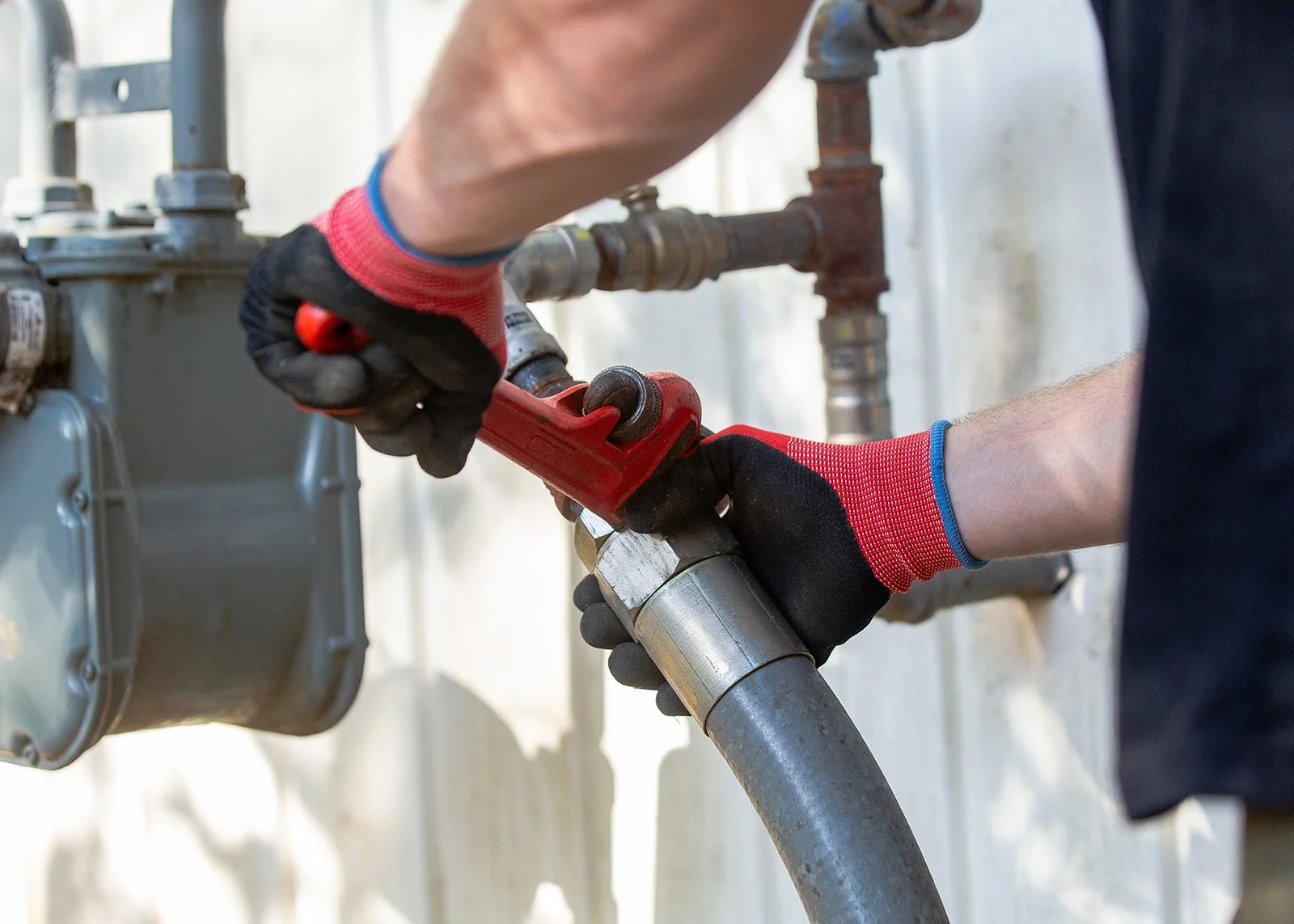 Modern house with wooden exterior in a mountain landscape with grassy foreground and mountains in the background.