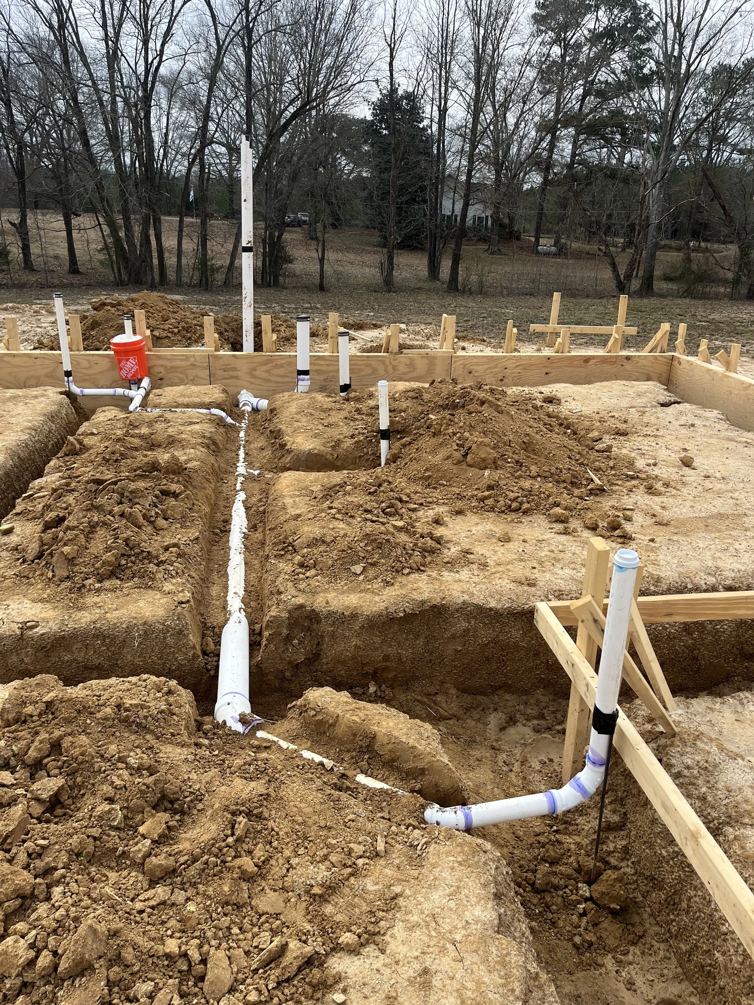 Scenic landscape of mountains, a lake, and grassy hills under overcast sky.
