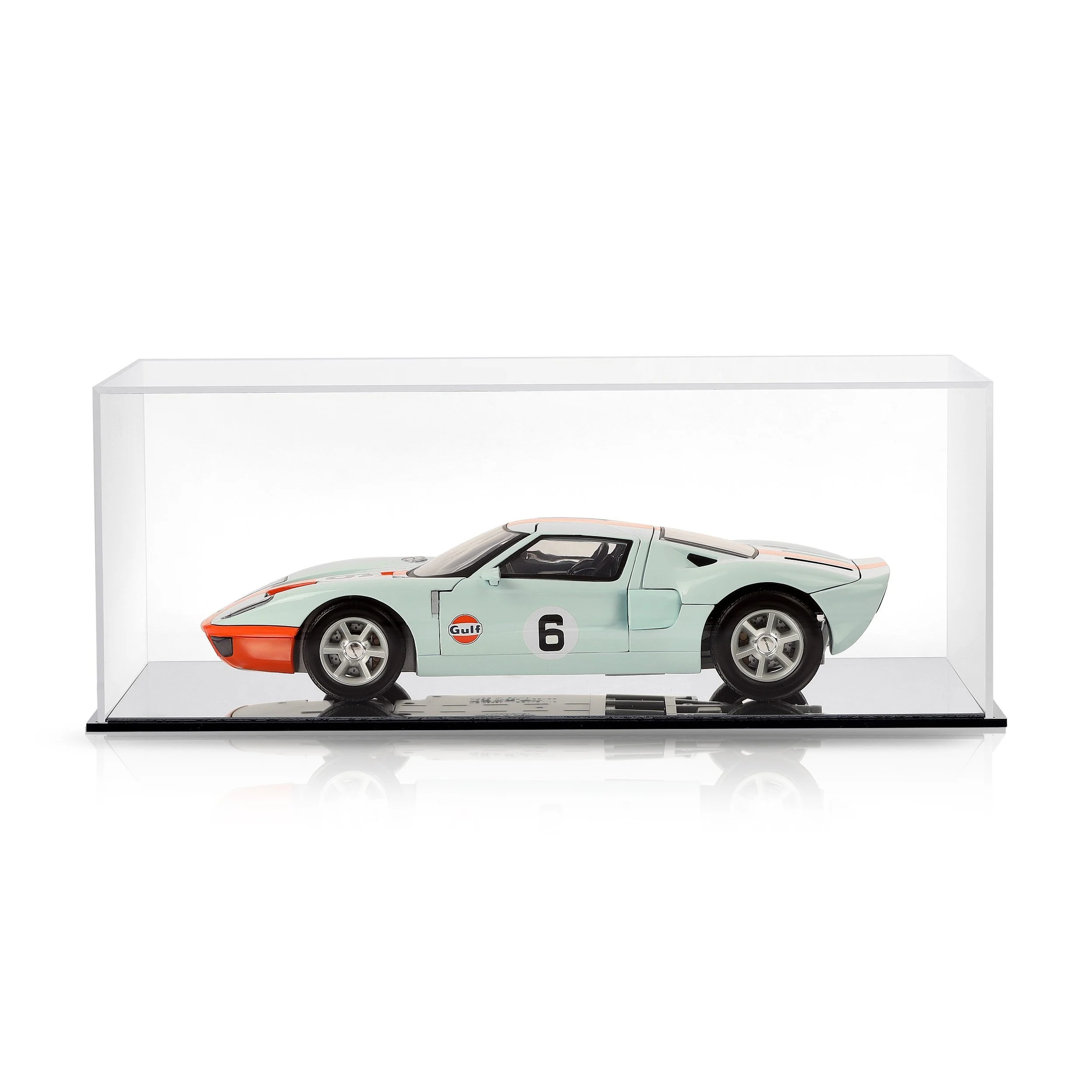 Model race car inside a clear display case, featuring a white body with orange accents, Gulf logo, and racing number 6.