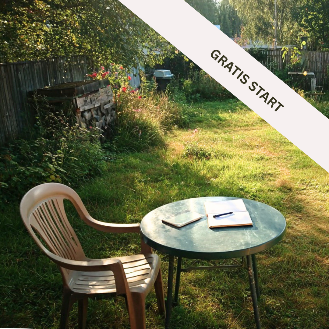 En have med et rundt bord med en notesbog, en åben notesbog med en pen, og en plastikstol. I baggrunden er der en træstak, blomster og en hæk. Solskin skinner ned over græsset.