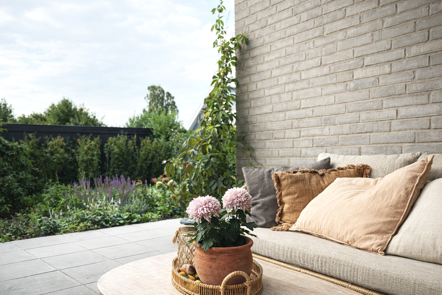Familiehave i skandinavisk stil, frodige bede og naturstensti. Lys og indbydende stemning med grønne og blomstrende planter i afdæmpede farver.