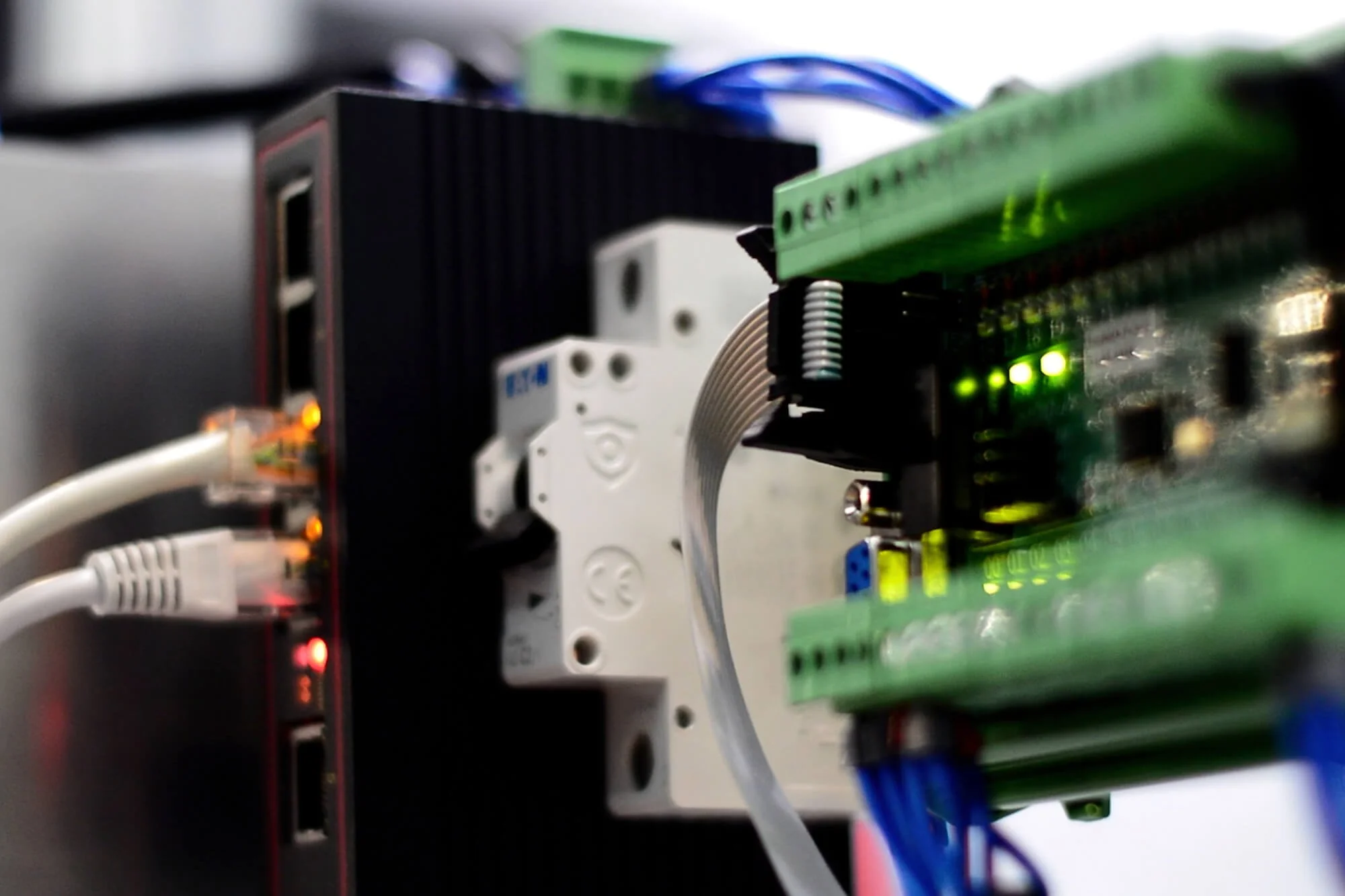 Close-up of an electronic circuit with various connected components, including a green circuit board, wires, and LED indicator lights.