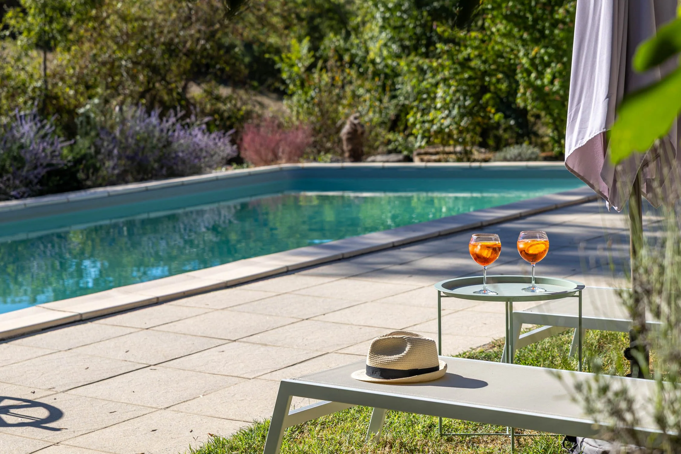 Cocktails by the pool at Les Mirabelles on a sunny day.