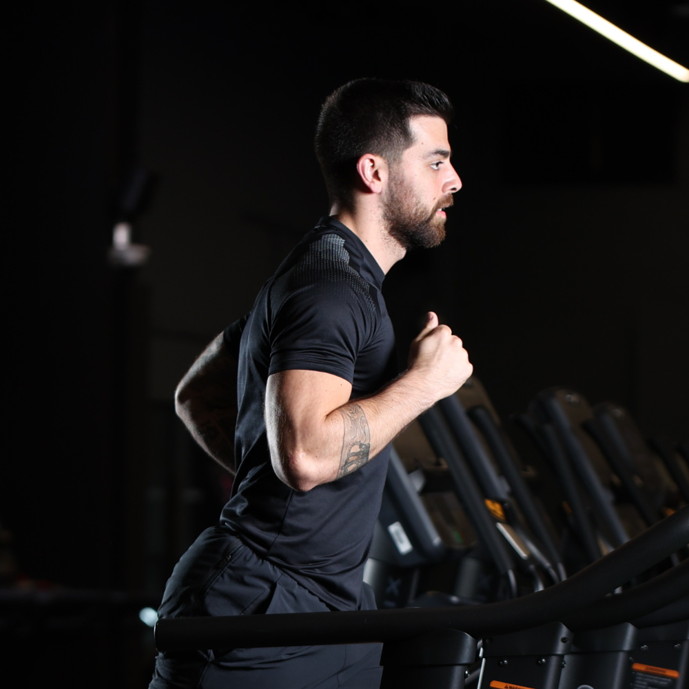 A man running on a treadmill in a gym.