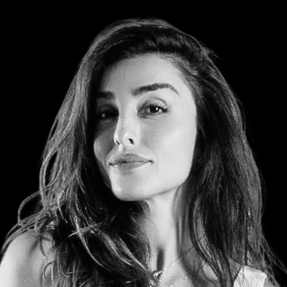 Black and white portrait of a woman with long, wavy hair, smiling subtly.